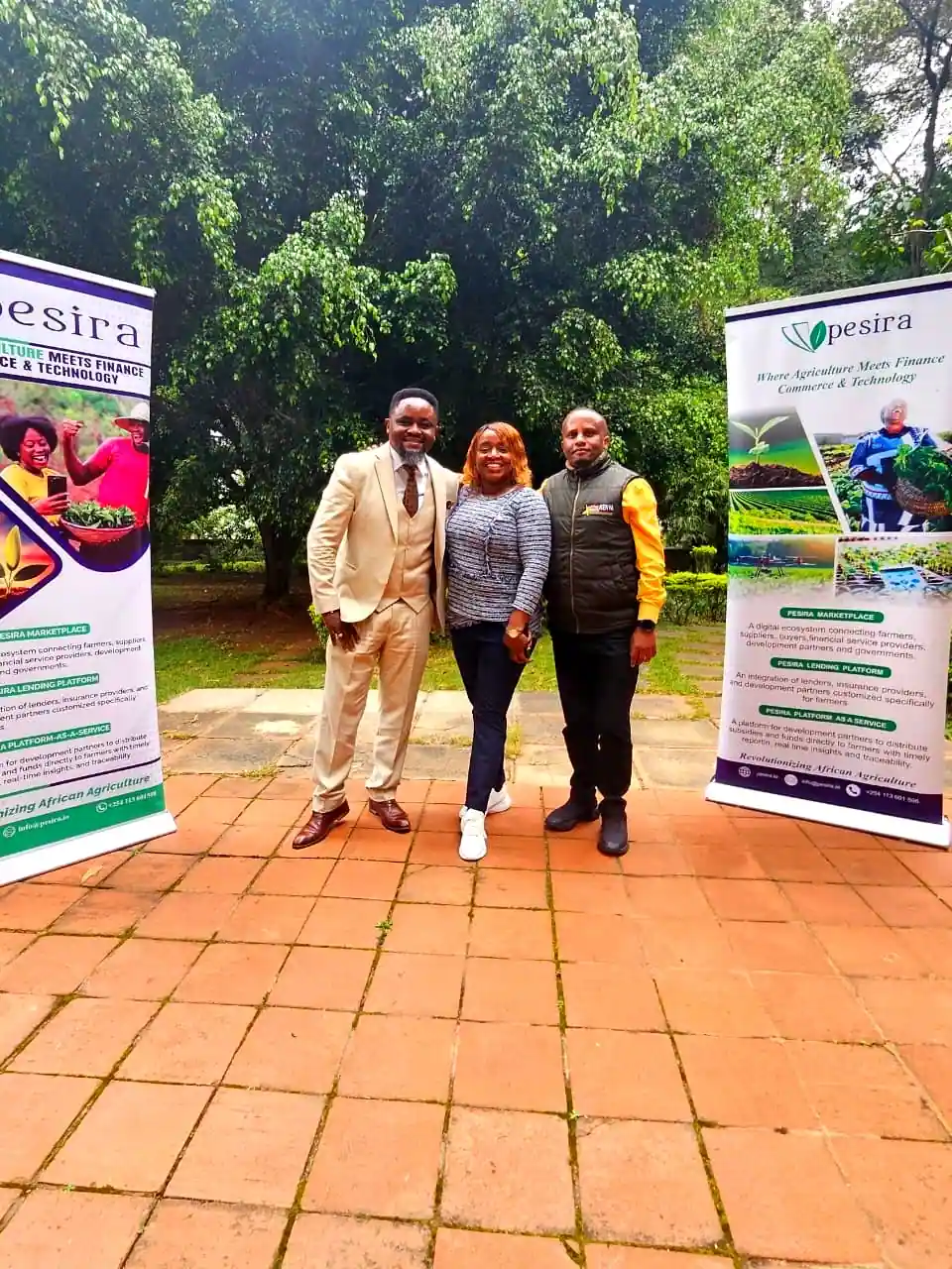 Tahadhari and Pesira teams at the MOU signing in Nairobi, flanked by Pesira banners